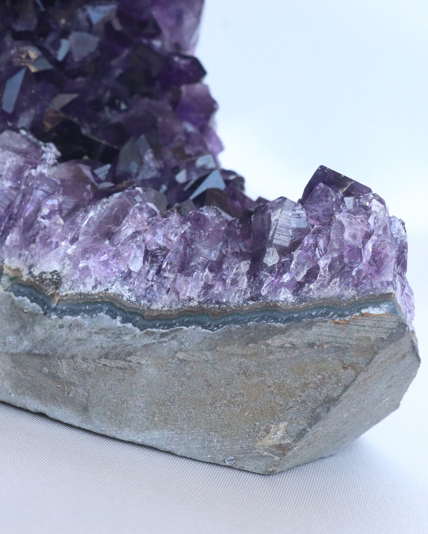 Dark purple amethyst sculpture moon shape with raw points, detail photo.
