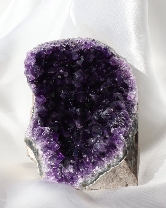 Dark purple amethyst sculpture with raw points, photo taken from the front.